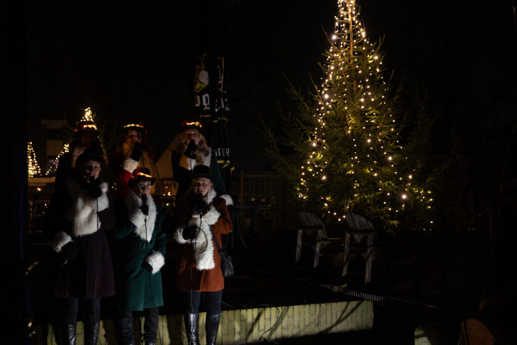 Koor bij verlichte kerstboom